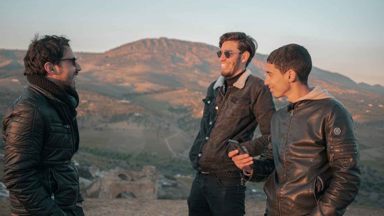 Three young men laughing and enjoying the outdoors in Fes, Morocco.